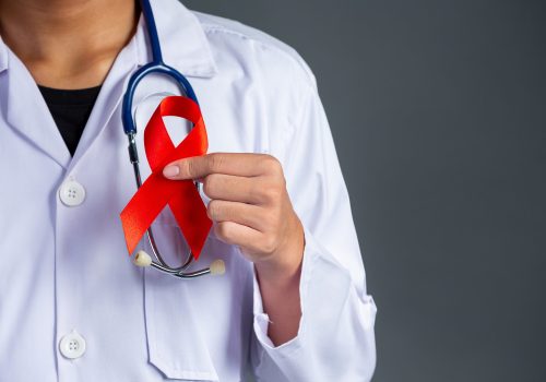 The doctor holds a red ribbon, HIV awareness awareness, World AIDS Day and World Sexual Health Day.